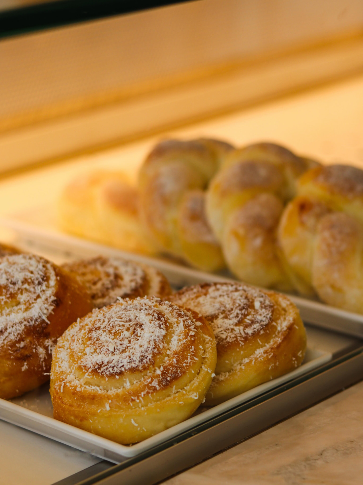 Bandeja de rosquinhas com coco ralado na vitrine da padaria
